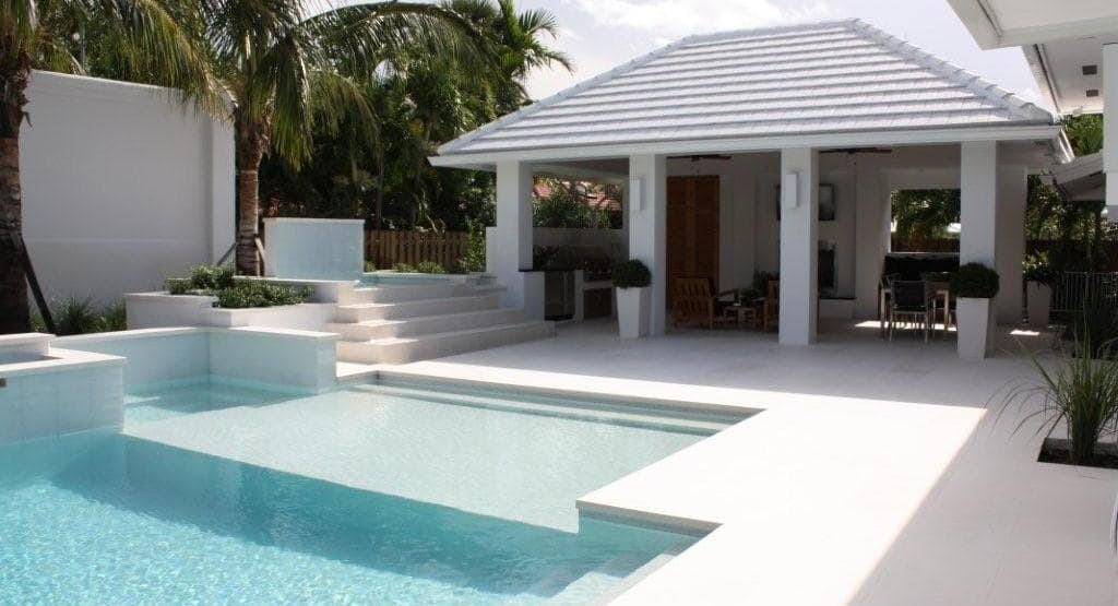 Travertine under a portico with white pool coping tiles